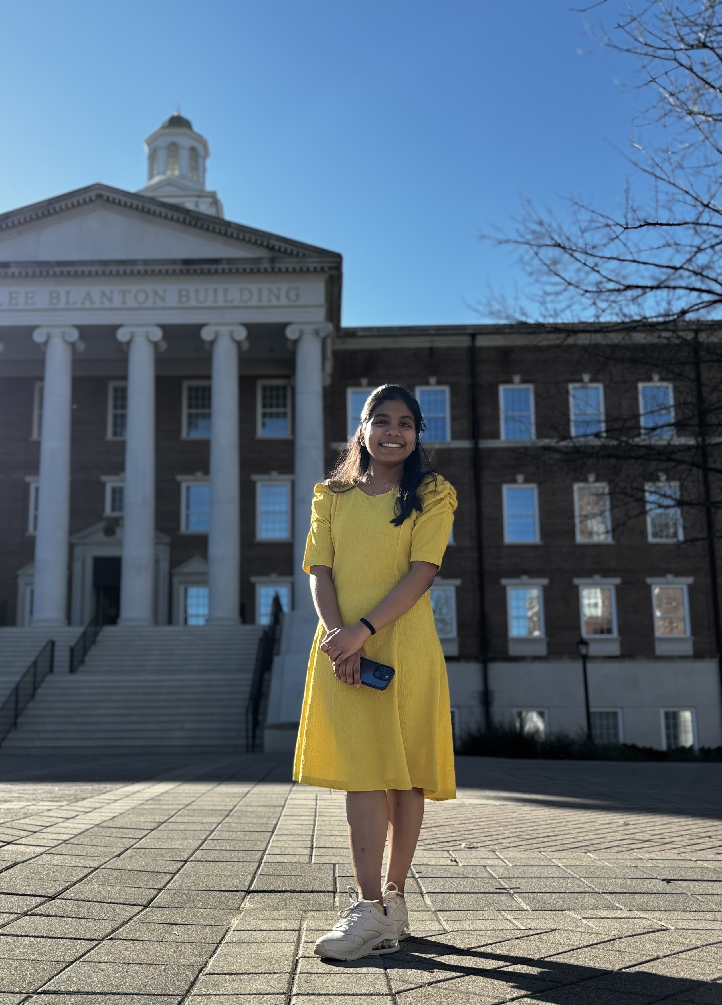 Alumna Courtney Kelly sits outside Caruth Hall