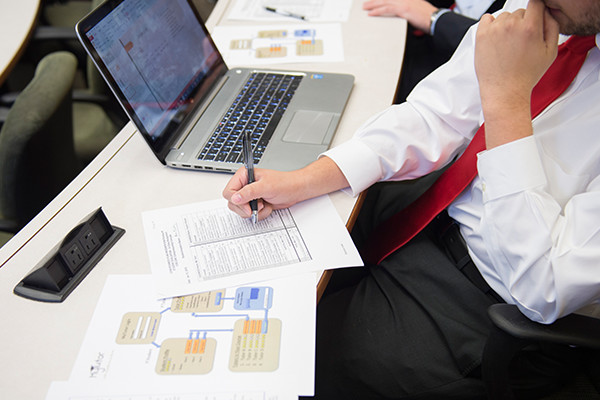 A man works on business in front of a laptop.