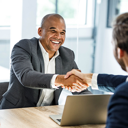 Happy businessmen shaking hands on a meeting in the office