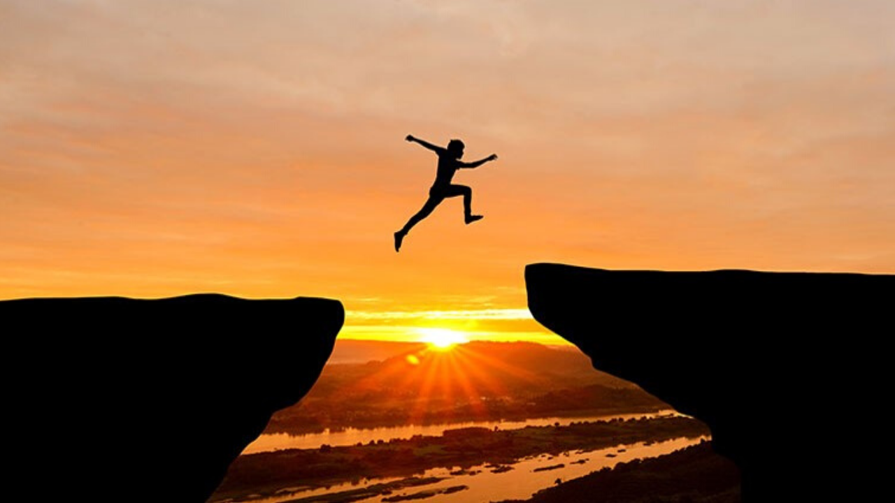 person jumping over cliff