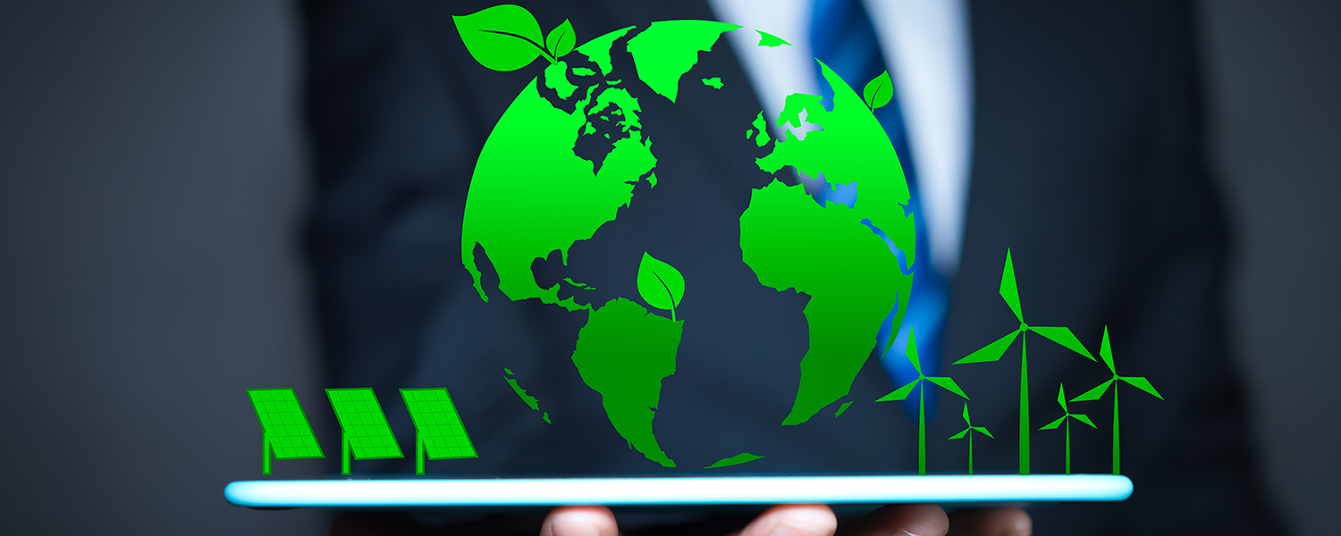 A businessman holding up a green globe with solar panels and wind turbines and green leaves sprouting from the continents of the globe.