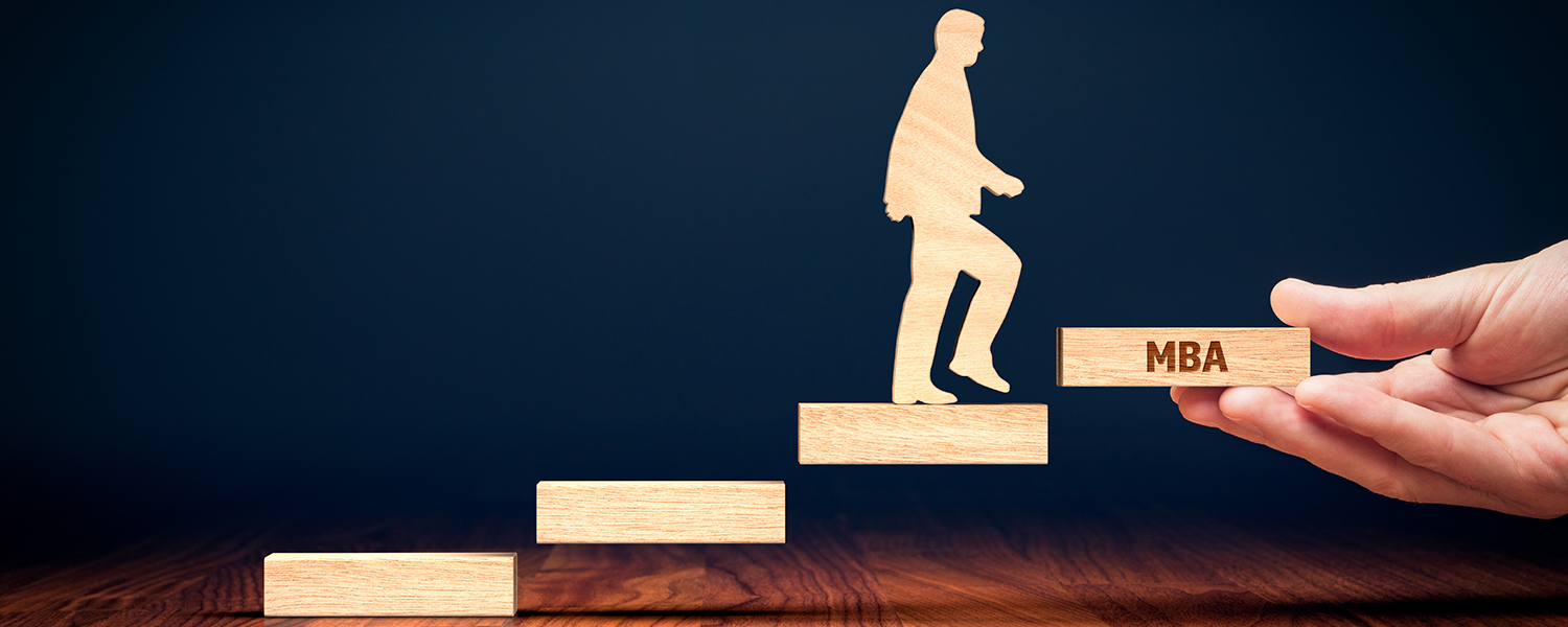A wooden man is climbing wooden four wooden steps. The fourth step is labeled "MBA"
