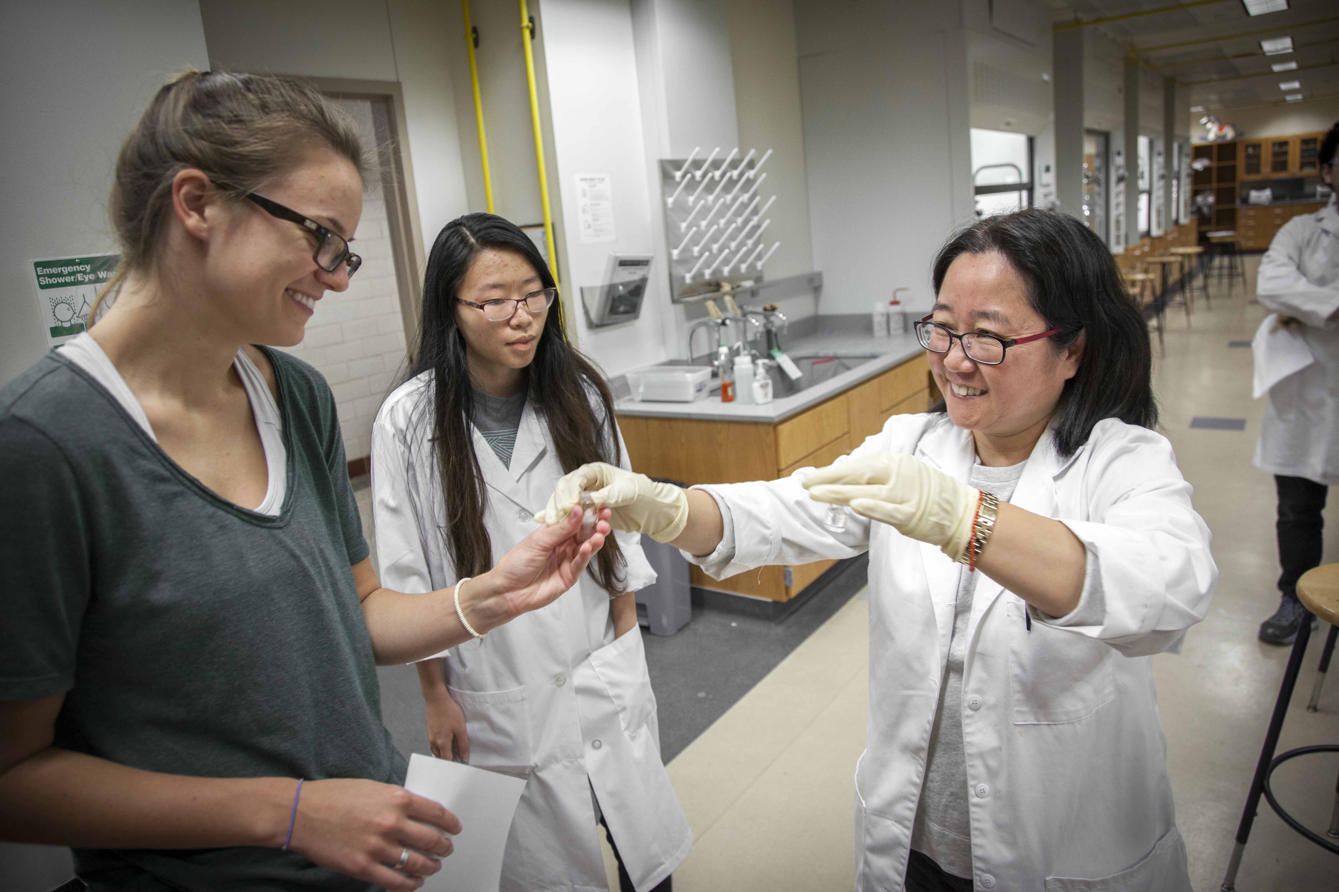 faculty and students holding lab equipment