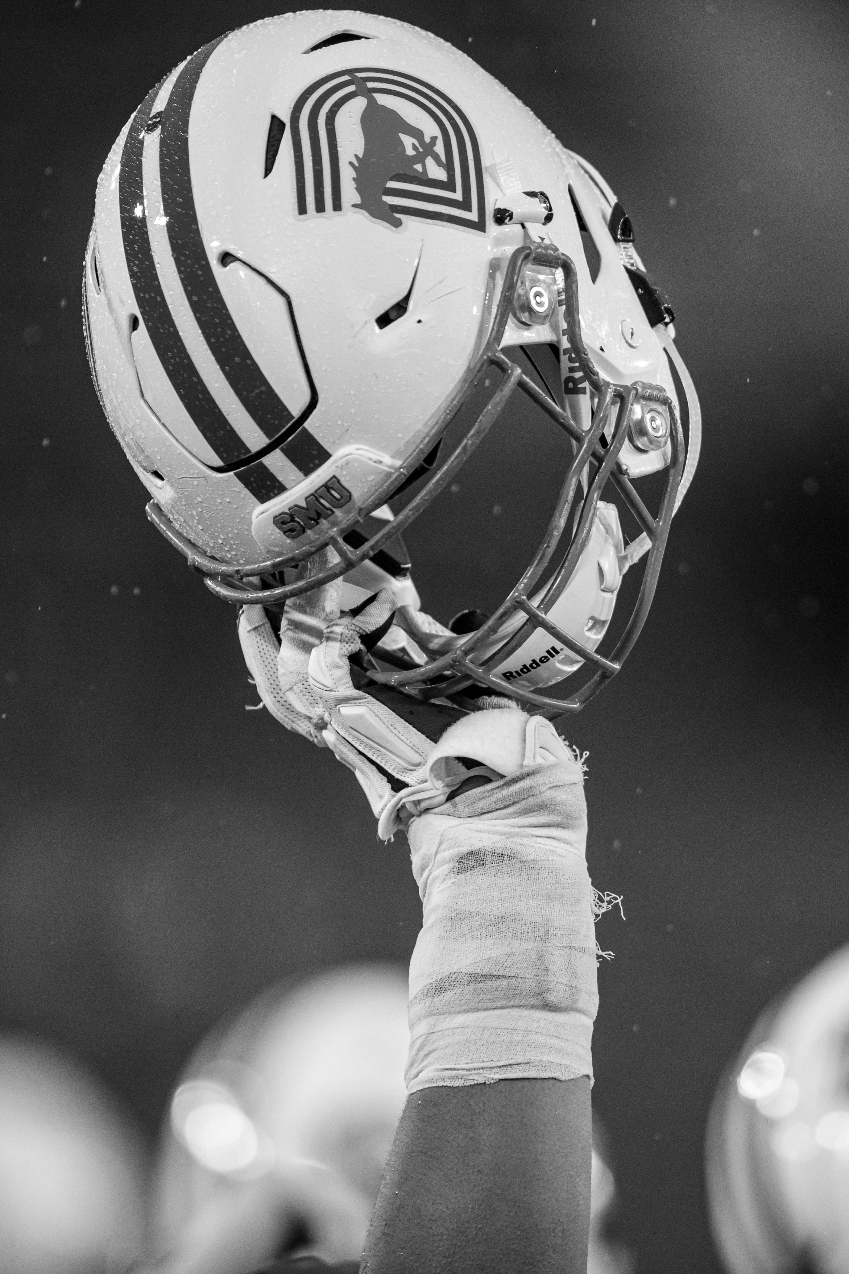 Image of football player's hand holding up a 色花堂_色花堂 98堂 Mustangs helmet