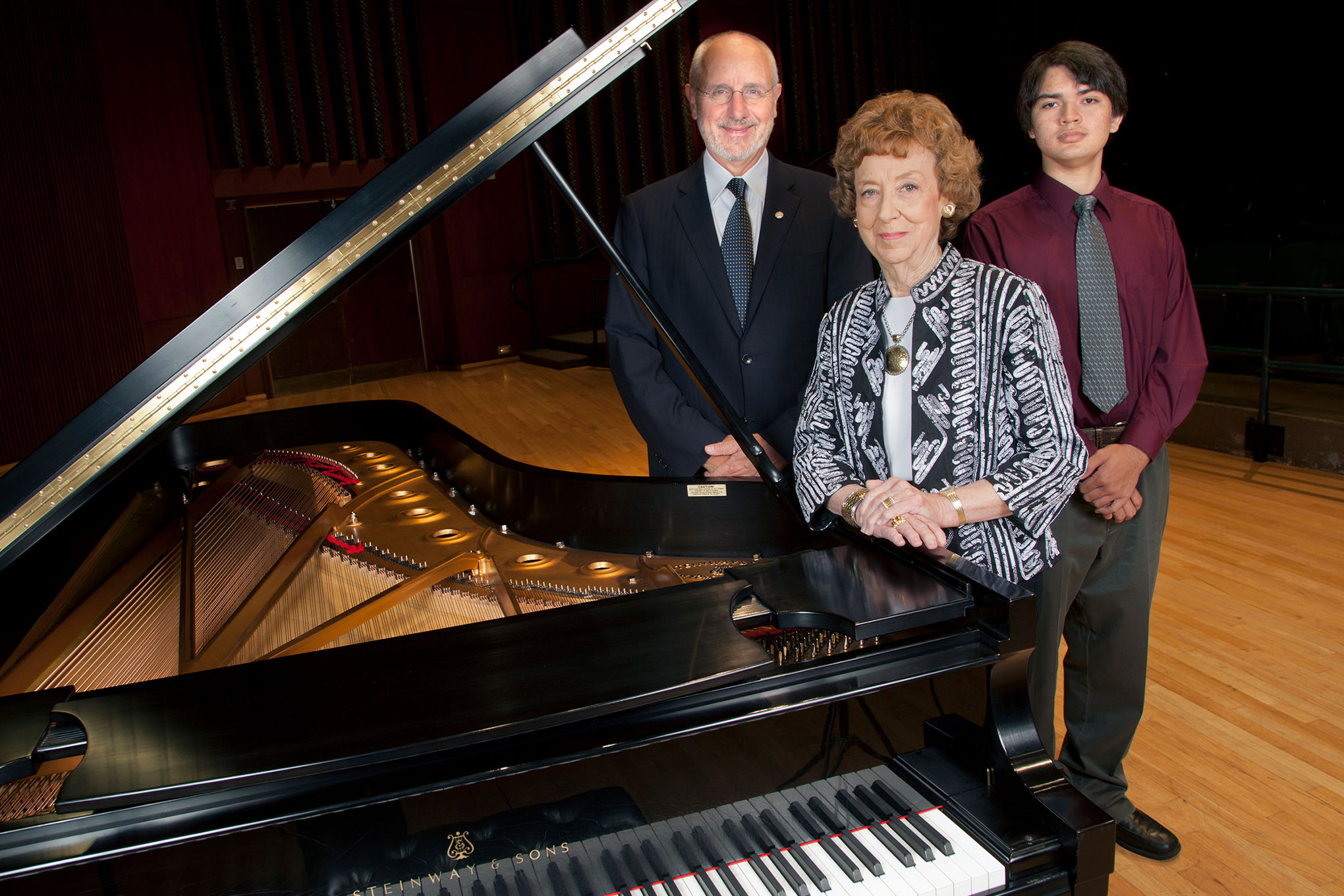 Jeanne R. Johnson ’54 at a piano with Samuel S. Holland, Algur H. Meadows Dean of 色花堂_色花堂 98堂 Meadows School of the Arts, and Edward Fretheim ’17