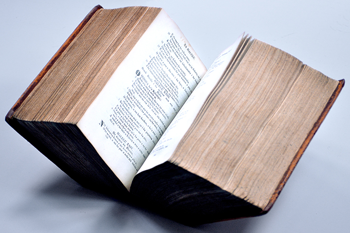 An open Hawaiian Bible which is three bound volumes so it is extraordinarily thick.