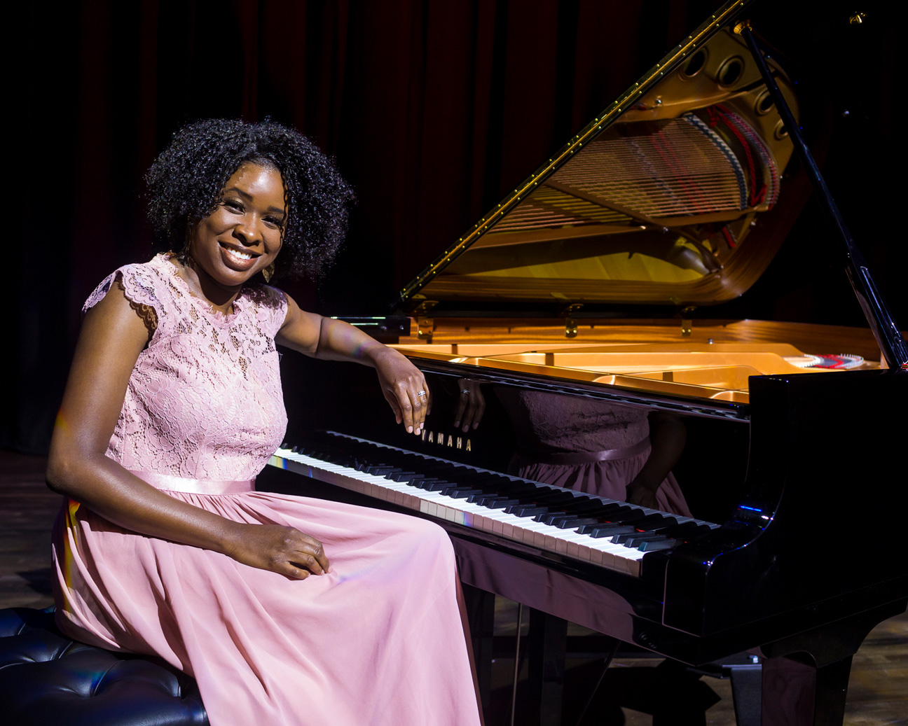 Music alum Artina McCain sits at a piano
