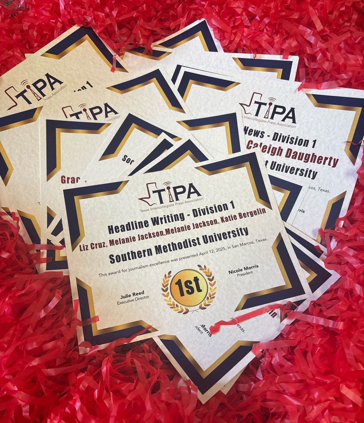 Overhead shot of a pile of award certificates for journalism students