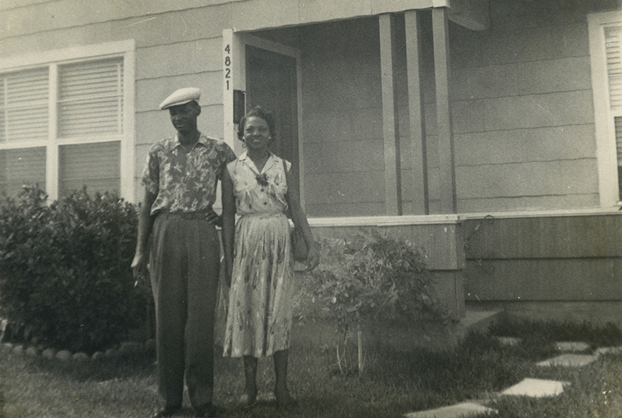 A couple stands in front of a home