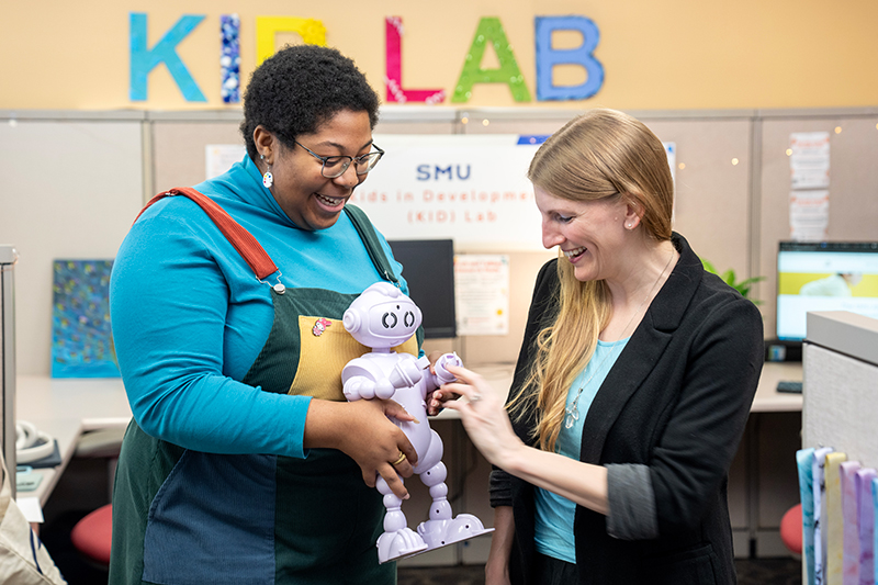 Two education researchers work with a robot toy in the 色花堂_色花堂 98堂 KID Lab