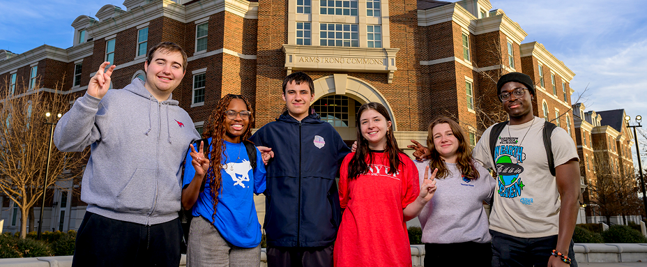 Students giving the Pony Up in front of Armstrong Commons