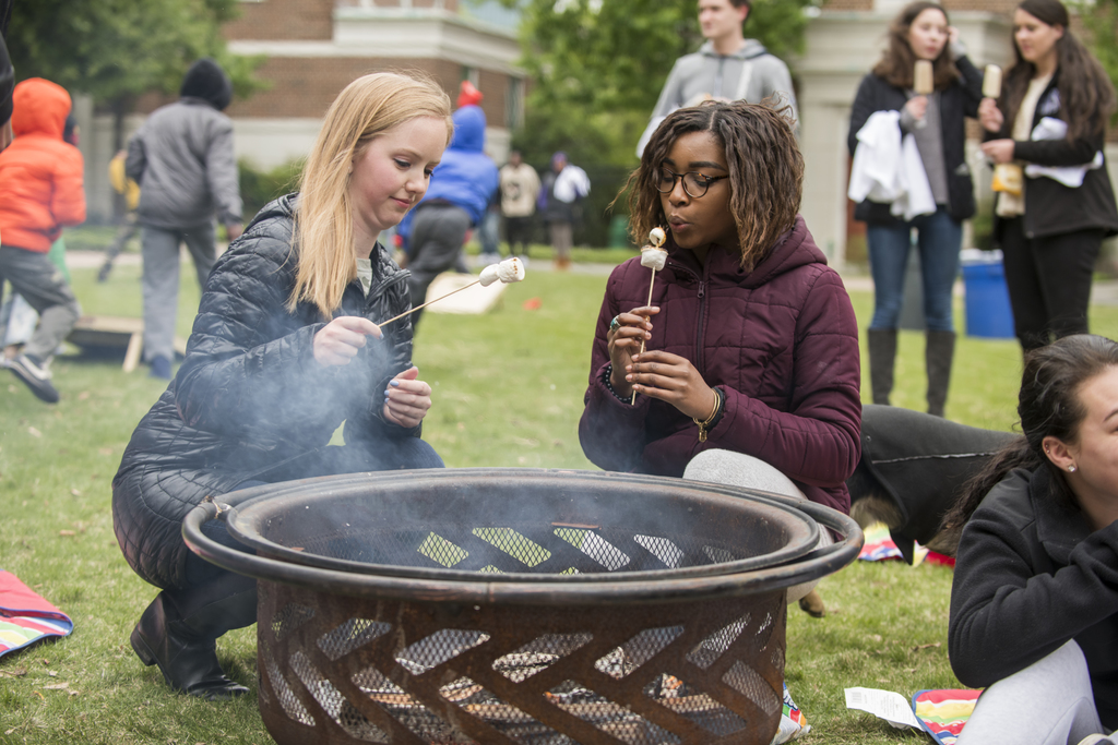 Students by fire enjoying smores