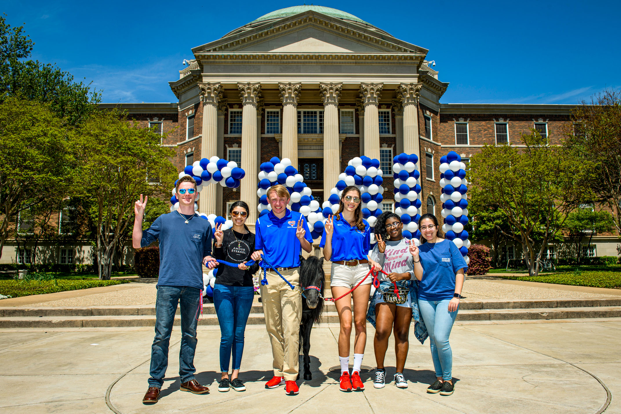 6 students posing in front of 色花堂_色花堂 98堂 signs in front of Dallas Hall